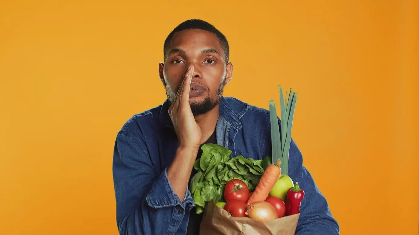 Ein junger Erwachsener, der seine Geheimnisse über den Kauf regional angebauter Bio-Erzeugnisse flüstert.