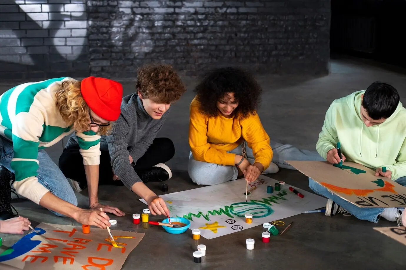 Gesamtaufnahme von Menschen, die auf dem Boden Banner herstellen.